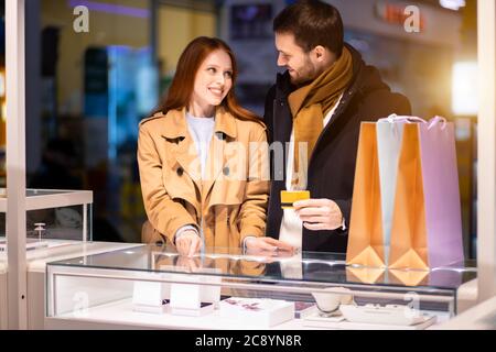 Liebe Konzept. Schöne schöne niedliche junge kaukasische Paar zusammen im Juweliergeschäft, wollen goldenen Ring kaufen Stockfoto