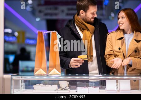 Junge kaukasische Paar in den Geschäften, beschlossen, Schmuck für Frauen in Mall.excited rothaarige Frau und jungen bärtigen Mann zusammen kaufen Stockfoto