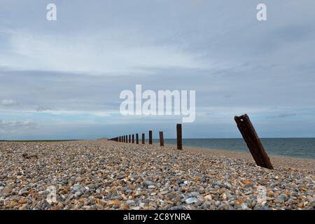 Die Überreste der Meeresverteidigung rosten am Kiesstrand von Cley-Next-the Sea, Norfolk, England, UK Stockfoto