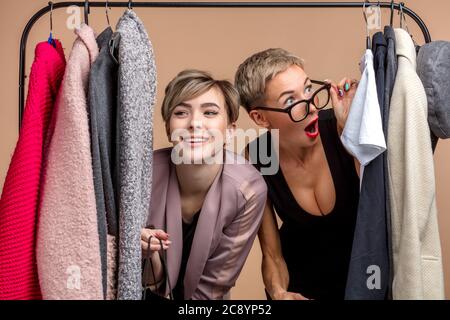 Emotionale Mädchen in Brille hilft ihrem Freund, ein Outfit zu wählen. Nahaufnahme Stockfoto