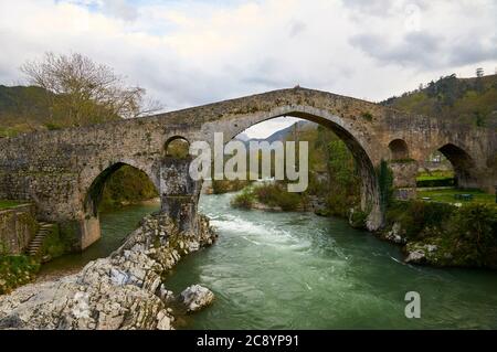 Die Steinbrücke aus dem 14. Jahrhundert, die fälschlicherweise als "römische Brücke" über den Fluss Sella bezeichnet wird (Cangas de Onís, Fürstentum Asturien, Spanien) Stockfoto