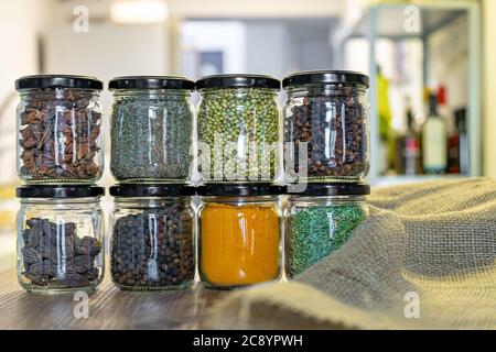 Gewürze und Kräuter in Gläsern zum Kochen, indische Gewürze, bunt Stockfoto