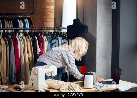 Junge blonde Frau lernen Messung, mit Laptop während der Arbeit. Close up Side view Foto, Online-Bildung, Beratung Stockfoto