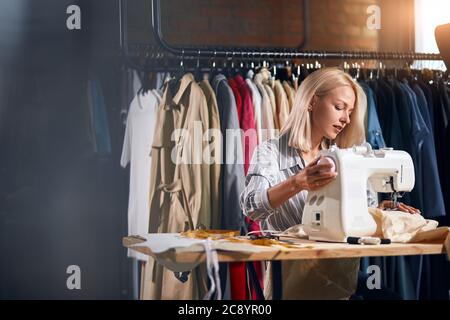 Junge schöne weibliche Schneiderinnen kooperiert in ihrem eigenen Studio. Close up Foto.Glas Wand, kopieren Raum Stockfoto