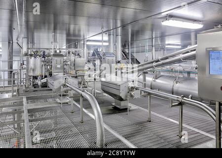 Neue industrielle Edelstahlmaschinen mit Bedienfeldern in einer kommerziellen Lebensmittelverarbeitungsanlage. Stockfoto