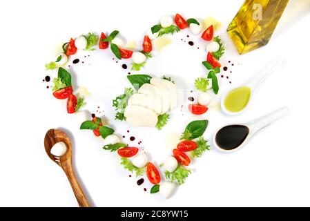 Tomate Mozzarella Herzform mit Basilikum isoliert auf weißem Hintergrund Stockfoto