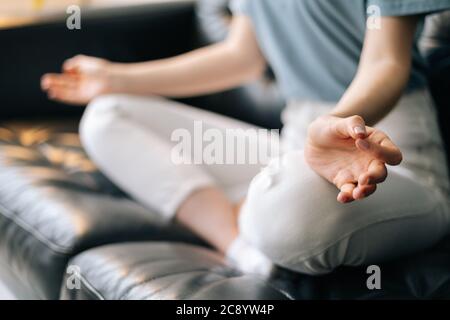 Nahaufnahme der Hände einer nicht erkennbaren Frau, die die Hände in der Mudra hält, die Heimyoga praktiziert Stockfoto