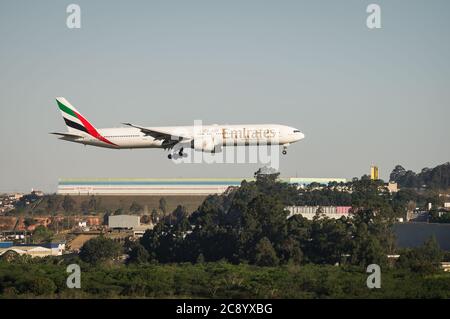 Emirates Boeing 777-31HER (Großraumflugzeug - Reg. A6-ECU) in kurzer Endzeit, vor berühren Start-und Landebahn 27L von Sao Paulo / Guarulhos International Airport. Stockfoto