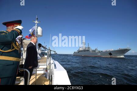 Der russische Präsident Wladimir Putin und Verteidigungsminister Sergei Shoigu beobachten die Überprüfung der Schiffe als die russische Marine Ropucha Klasse Korolev großes Landungsschiff Segel vorbei während der Militärparade zur russischen Marine Tag auf dem Fluss Newa und dem Hafen von Kronstadt am 26. Juli 2020 in St. Petersburg, Russland. Stockfoto