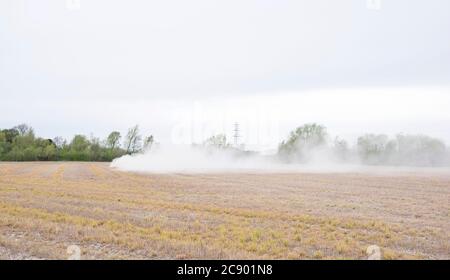 Traktor verteilt Dünger auf einem Feld Stockfoto