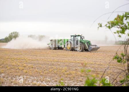 Traktor verteilt Dünger auf einem Feld Stockfoto