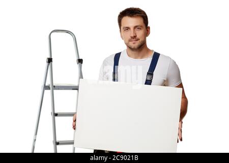 kaukasische Werkstatt Arbeiter in Uniform hält leere Tafel auf weißem Hintergrund Stockfoto