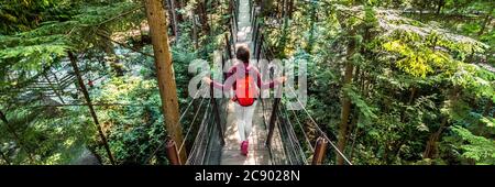 Kanada Reise Menschen Lifestyle Banner. Tourist Frau zu Fuß in der berühmten Attraktion Capilano Suspension Bridge in North Vancouver, British Columbia Stockfoto