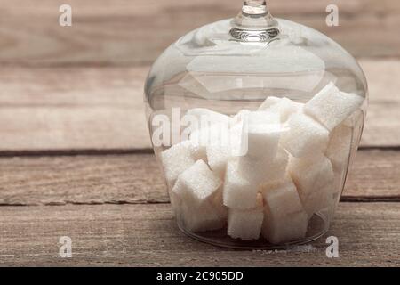 Cognac Glas close up Kopf über Fersen mit dem raffinierten Zucker in Würfel auf einem Holztisch aus alten Brettern gefüllt, niemand. Stockfoto