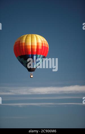 Eine Luftaufnahme eines Heißluftballons gegen einen blauen Himmel, der über der Idaho-Landseite schwebt. Stockfoto