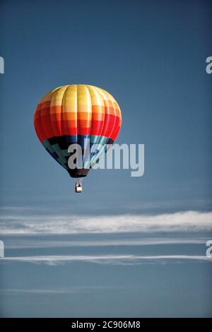 Eine Luftaufnahme eines Heißluftballons gegen einen blauen Himmel, der über der Idaho-Landseite schwebt. Stockfoto