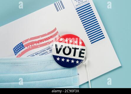 Umschlag, Wahlstift und Gesichtsmaske gegen Blau Stockfoto