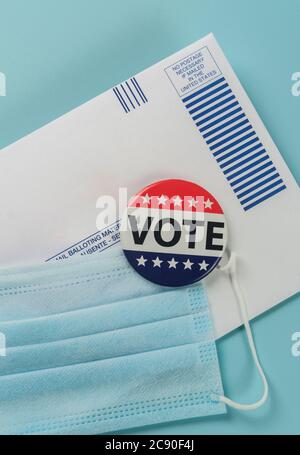 Umschlag, Wahlstift und Gesichtsmaske gegen Blau Stockfoto