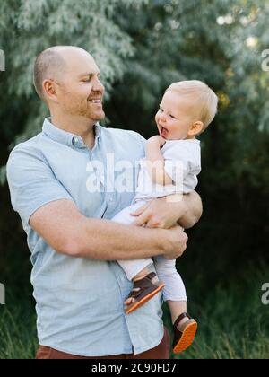 Außenportrait des Vaters, der Baby Sohn trägt Stockfoto