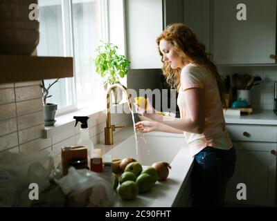 Frau waschen Zitrone Stockfoto