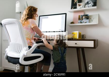 Mädchen (2-3) unterbricht Mutter von zu Hause aus Stockfoto