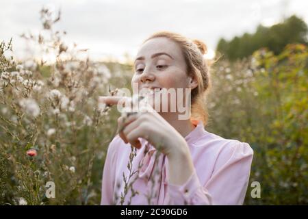 Russland, Omsk, Junge Frau auf der Wiese Stockfoto