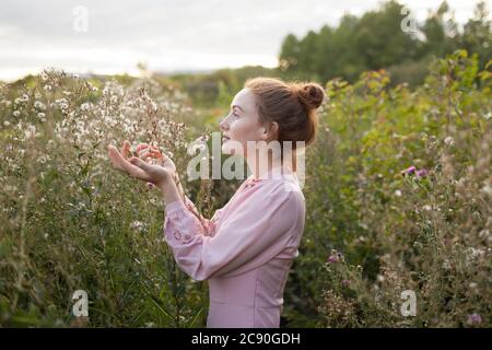 Russland, Omsk, Junge Frau auf der Wiese Stockfoto