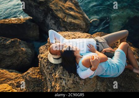Romantisches Paar auf Felsen am Meer entspannen Stockfoto