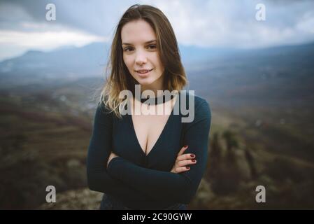 Ukraine, Krim, Porträt einer jungen Frau mit Bergtal im Hintergrund Stockfoto