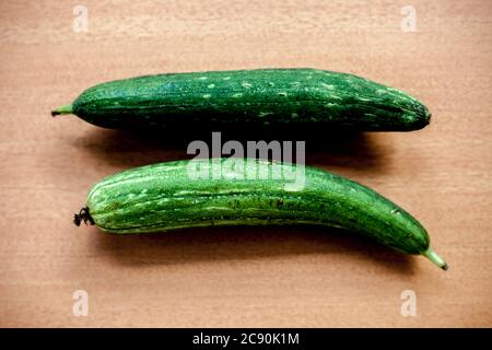 Nahaufnahme von rohem Galka oder Schwamm-Kürbis auf einer braunen Holzoberfläche. Stockfoto