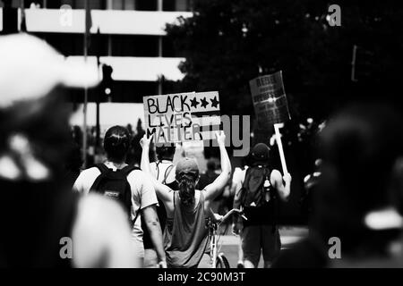 Protestierende mit Schild mit der Aufschrift "Black Lives Matter", während des Marsches gegen Trumps Polizeistaat, Washington, DC, USA, schwarz-weiß Stockfoto