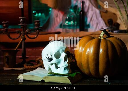 Halloween-Wochenenden. Halloween-Dekorationen. Kürbis mit Totenkopf. Kürbis und Totenkopf in der gruseligen Holzhaus - Halloween-Szene. Stockfoto