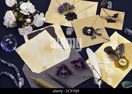 Stillleben mit verzierten Umschlägen, Rosenblüten, Kristall und magischen Objekten. Mystischer und romantischer Hintergrund mit Kopierraum und leerem, vintage romanti Stockfoto