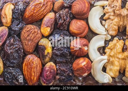 Hausgemachte Schokoladenkuchen mit Haselnüssen, Cashewkernen, Walnüssen, Pflaumen und Mandeln aus nächster Nähe. Stockfoto