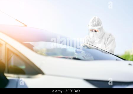 Medizinisches Personal, das einen Krankengeschichte-Bericht eines Patienten als Reaktion auf COVID-19 in Drive-Thru-Punkt aufnahm. Stockfoto