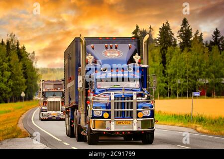 Kundenspezifischer Scania LS Sattelauflieger im Show-LKW-Konvoi durch ländliche Landschaft bei Sonnenuntergang. Stockfoto