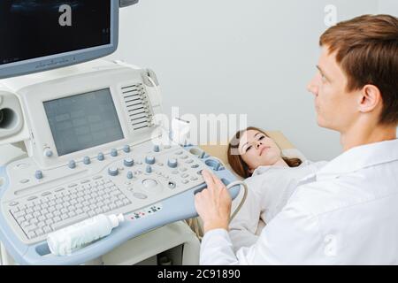 Arzt, der ein Bild auf dem Monitor sieht, während er einen Ultraschalluntersuchung an einem Patienten durchführt. Stockfoto