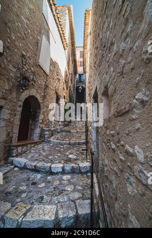 Eine gepflasterte Straße oder eine antike schmale Gasse mit Treppen zeigt, wie der Lebensstil in einem mittelalterlichen Dorf - Saint Paul de Vence, Frankreich - ausgesehen haben muss Stockfoto