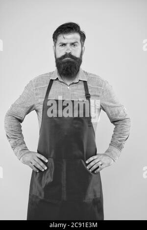 Bärtiger Mann in Koch Uniform. Reifer Verkäufer. Koch in roter Schürze. Restaurantpersonal. Hobby Kochen. Viele Liefertage Optionen. Die ganze Familie würde es genießen. Kochen zu Hause. Hilfe im Haus. Stockfoto