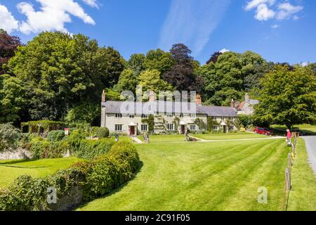 Eine Reihe von traditionellen Steinhütten auf Church Lawn in Stourton, einem kleinen Dorf in der Nähe von Stourhead, Wiltshire, Südwestengland an einem sonnigen Tag Stockfoto