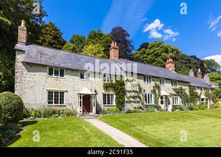 Eine Reihe von traditionellen Steinhütten auf Church Lawn in Stourton, einem kleinen Dorf in der Nähe von Stourhead, Wiltshire, Südwestengland an einem sonnigen Tag Stockfoto