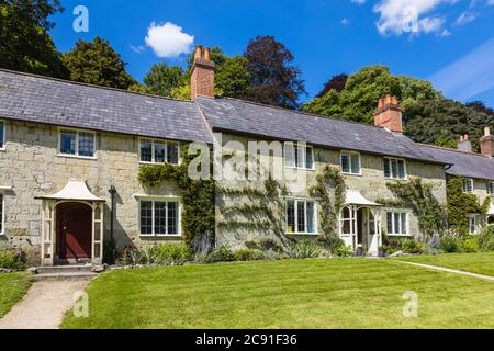 Eine Reihe von traditionellen Steinhütten auf Church Lawn in Stourton, einem kleinen Dorf in der Nähe von Stourhead, Wiltshire, Südwestengland an einem sonnigen Tag Stockfoto