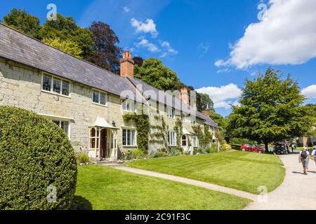 Eine Reihe von traditionellen Steinhütten auf Church Lawn in Stourton, einem kleinen Dorf in der Nähe von Stourhead, Wiltshire, Südwestengland an einem sonnigen Tag Stockfoto