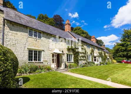 Eine Reihe von traditionellen Steinhütten auf Church Lawn in Stourton, einem kleinen Dorf in der Nähe von Stourhead, Wiltshire, Südwestengland an einem sonnigen Tag Stockfoto