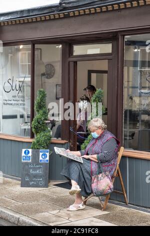 Ein Kunde wartet auf Termine außerhalb von Slix, dem lokalen Friseursalon, da er nach monatelanger Sperre in Presteigne, Powys, Wales, Großbritannien wieder eröffnet wird Stockfoto