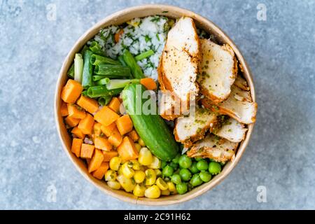 Take Away Healthy Organic Turkish Protein Bowl mit gerösteten Chicken Scheiben, Jasminreis, Gurke, Schnittlauch, grünen Erbsen, Karotten und Mayonnaise Joghurt S Stockfoto