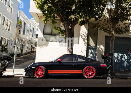 Seitenansicht des Porsche 911 Carrera mit modifizierten Rädern und Abtriebspoiler, geparkt auf einer Anhöhe in San Francisco CA. Stockfoto