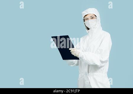 Arzt in einem weißen Kostüm Notizen in einer Zwischenablage. Stockfoto
