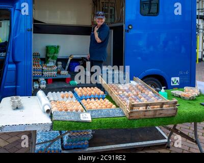 Lächelnde Dame Stallholder Verkauf von Eiern auf einem spezialisierten Bauernmarkt Stand in North Yorkshire Stockfoto