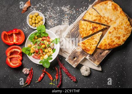 Köstlicher Salat mit gebratenem Halloumi-Käse, Tomaten, Paprika, Oliven und Rucola und Brot mit Käse. Mediterrane Gerichte. Draufsicht Stockfoto